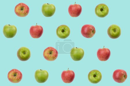 Téléchargez les photos : Modèle de fruits colorés de pommes rouges fraîches et vertes sur fond bleu. conception de texture pour les textiles, papier peint, tissu. De vue du dessus - en image libre de droit