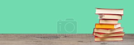 Photo for Composition with hardback books on wooden deck table and green background. Books stacking. Back to school. Copy Space. Education background. Banner - Royalty Free Image