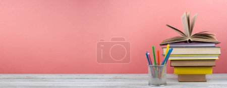 Photo for Book stacking. Open book, hardback books on wooden table and blue background. Back to school. Copy space for text. Banner - Royalty Free Image