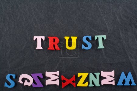 Photo for TRUST word on black board background composed from colorful abc alphabet block wooden letters, copy space for ad text. Learning english concept - Royalty Free Image