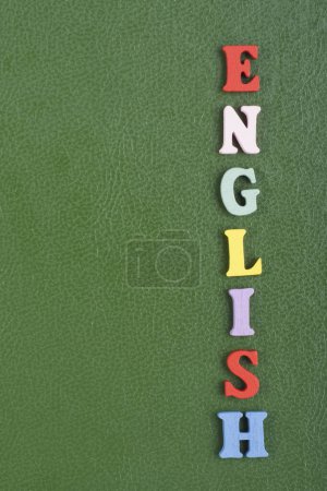 Foto de Palabra en inglés sobre fondo verde compuesta de letras de madera coloridas del bloque del alfabeto abc, espacio de copia para el texto del anuncio. Aprender el concepto inglés - Imagen libre de derechos