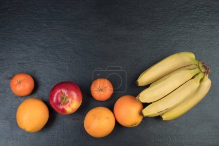 Photo for Fruits. Bananas, apples, oranges tangerines on a black background - Royalty Free Image