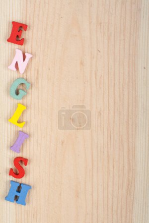 Foto de Palabra en inglés sobre fondo de madera compuesta de letras de madera coloridas del bloque abc del alfabeto, espacio de copia para el texto del anuncio. Aprender el concepto inglés - Imagen libre de derechos