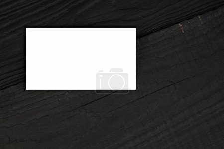 Téléchargez les photos : Cartes de visite vierges sur la table en bois noir. Modèle d'identification. Vue du dessus - en image libre de droit