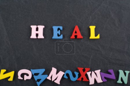 Photo for HEAL word on black board background composed from colorful abc alphabet block wooden letters, copy space for ad text. Learning english concept - Royalty Free Image