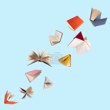 Foto de Libros coloridos de tapa dura volando aislados sobre fondo azul - Imagen libre de derechos