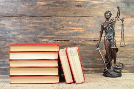 Photo for Law concept - Open law book, Judge's gavel, scales, Themis statue on table in a courtroom or law enforcement office. wooden background. - Royalty Free Image