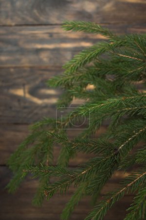Foto de Composición navideña de ramas de abeto y bayas de viburnum sobre un fondo de madera - Imagen libre de derechos