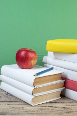 Photo for Books stacking. Books on wooden table and green background. Back to school. Copy space for ad text - Royalty Free Image