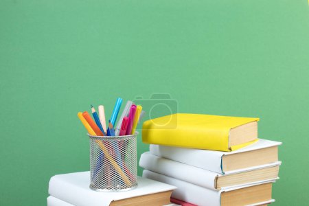 Foto de Libros apilados. Libros sobre mesa de madera y fondo verde. De vuelta a la escuela. Copiar espacio para texto del anuncio - Imagen libre de derechos