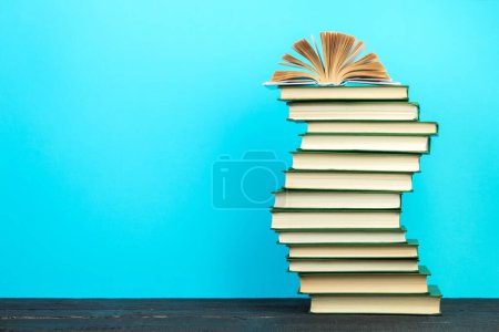 Foto de Libro abierto, libros de tapa dura sobre mesa de madera, sobre fondo azul. De vuelta a la escuela. Copia espacio para texto. Formación profesional - Imagen libre de derechos