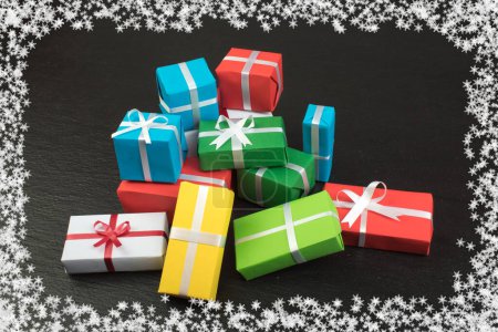 Foto de Cajas de regalo y regalo colorido para Navidad en pizarra. Vista superior con espacio de copia - Imagen libre de derechos