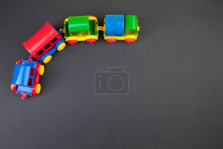 Téléchargez les photos : Jouet pour enfants, une locomotive à vapeur multicolore sur fond noir. Pour le développement de l'enfant. - en image libre de droit