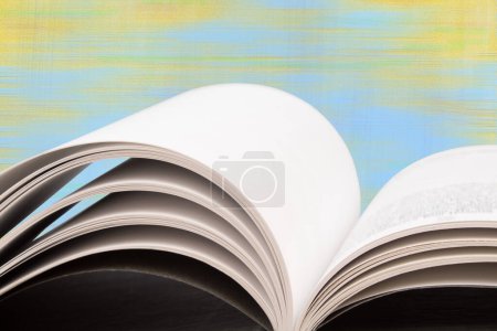 Photo for Composition with hardback books, fanned pages on wooden deck table and blue background. Books stacking. Back to school. Copy Space. Education background. Tuition payment. - Royalty Free Image
