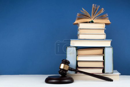 Foto de Concepto de ley libro abierto con jueces de madera martillo en la mesa en una sala de tribunal o la oficina de aplicación de la ley, fondo azul. Copiar espacio para texto - Imagen libre de derechos