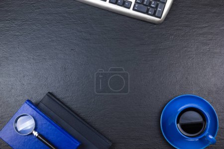 Téléchargez les photos : Bureau noir table de bureau avec ordinateur, stylo et une tasse de café, beaucoup de choses. Vue supérieure avec espace de copie - en image libre de droit