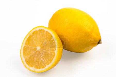 Foto de Aislamiento de limón sobre blanco. Fruto de limón entero y medio con hojas. Vista lateral en blanco. Con camino de recorte - Imagen libre de derechos
