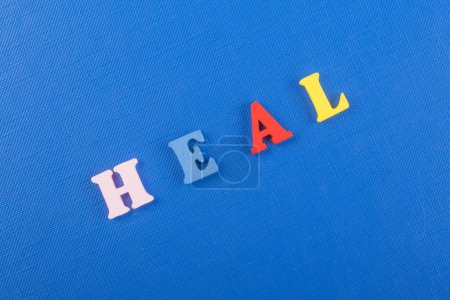 Photo for HEAL word on blue background composed from colorful abc alphabet block wooden letters, copy space for ad text. Learning english concept - Royalty Free Image