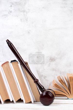 Photo for Law concept - Open law book, Judge's gavel, scales, Themis statue on table in a courtroom or law enforcement office. Wooden table, gray concrete background - Royalty Free Image