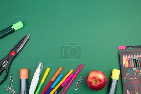 Foto de De vuelta a la escuela. Papelería sobre una mesa verde. Escritorio de oficina con espacio para copias. Puesta plana - Imagen libre de derechos