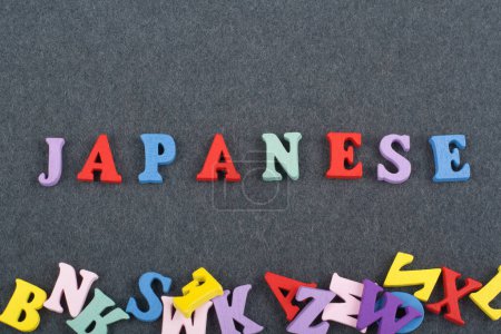 Photo for Japanese word on black board background composed from colorful abc alphabet block wooden letters, copy space for ad text. Learning english concept - Royalty Free Image