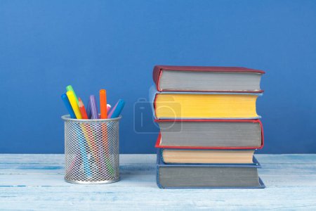 Photo for Book stacking. Open book, hardback books on wooden table and blue background. Back to school. Copy space for text - Royalty Free Image
