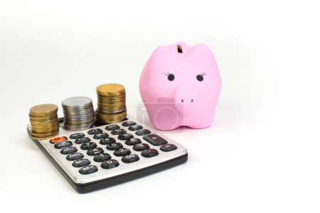 Foto de El de monedas, calculadora, alcancía rosa sobre fondo blanco aislado. Vista superior con espacio de copia
. - Imagen libre de derechos
