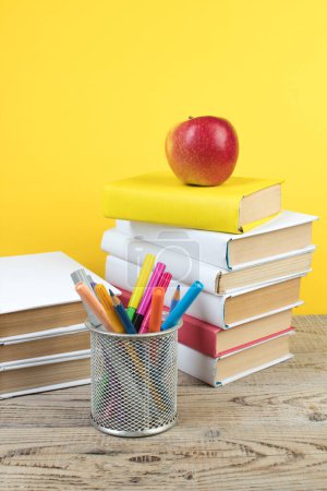 Foto de Libros apilados. Libros sobre mesa de madera y fondo amarillo. De vuelta a la escuela. Copiar espacio para texto del anuncio - Imagen libre de derechos