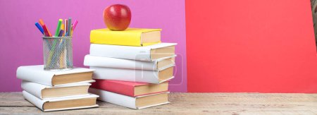 Foto de Libros apilados. Libros sobre mesa de madera y fondo rojo, púrpura. De vuelta a la escuela. Copiar espacio para texto del anuncio - Imagen libre de derechos
