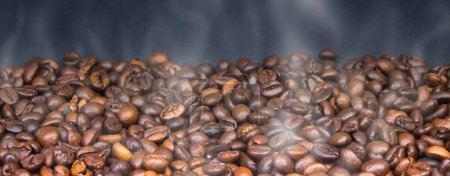 Téléchargez les photos : Graines de café torréfiées brunes, gros plan à la vapeur sur un fond sombre - en image libre de droit