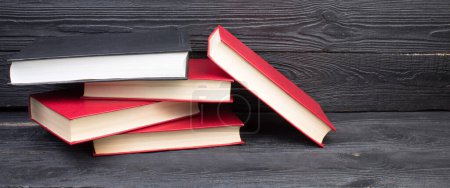 Téléchargez les photos : Livres rouges sur une table en bois noir. Concept de droit, concept d'éducation avec espace de copie pour le texte de votre annonce - en image libre de droit