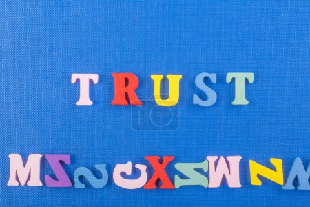 Photo for TRUST word on blue background composed from colorful abc alphabet block wooden letters, copy space for ad text. Learning english concept - Royalty Free Image