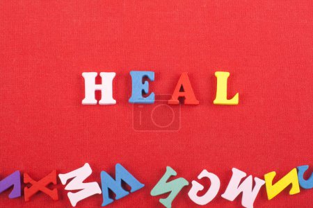 Photo for HEAL word on red background composed from colorful abc alphabet block wooden letters, copy space for ad text. Learning english concept - Royalty Free Image