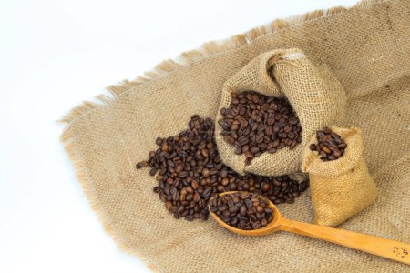 Photo for Opened burlap bags, a cup of coffee, scattered whole coffee beans on a white background - Royalty Free Image