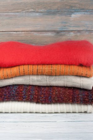 Suéteres de lana. Montón de prendas de punto de invierno sobre fondo de madera, suéteres, prendas de punto, espacio para el texto