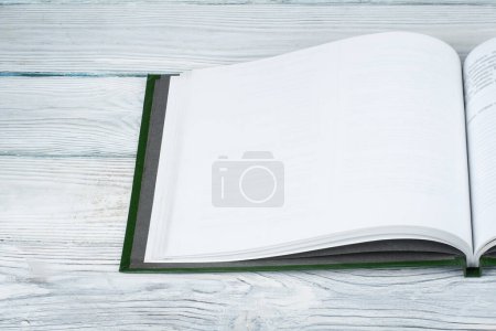 Photo for Open book on wooden deck table and black board background. Back to School. Education concept with copy space for your ad text - Royalty Free Image