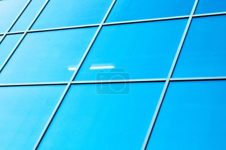 Téléchargez les photos : Façade vitrée. façade vitrée sur fond bleu. gratte-ciel modernes du centre-ville - en image libre de droit