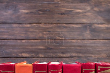 Photo for Composition with hardback books, fanned pages on wooden deck table and background. Books stacking. Back to school. Copy Space. Education background - Royalty Free Image