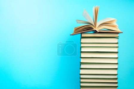 Foto de Libro abierto, libros de tapa dura sobre mesa de madera, sobre fondo azul. De vuelta a la escuela. Copia espacio para texto. Formación profesional - Imagen libre de derechos
