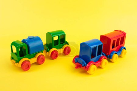 Téléchargez les photos : Jouet pour enfants, une locomotive à vapeur multicolore sur fond jaune. Pour le développement de l'enfant. - en image libre de droit