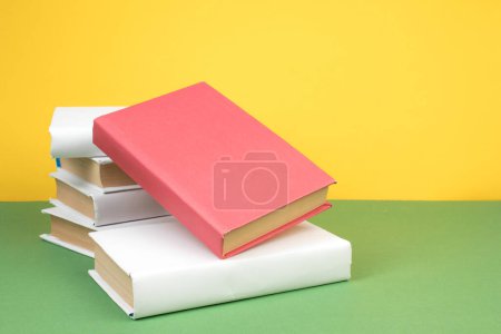 Téléchargez les photos : Empilement de livres. Ouvrez des livres à dos rigide sur table en bois et fond vert. Je retourne à l'école. Espace de copie pour texte publicitaire - en image libre de droit