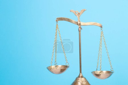 Rechtskonzept - Offenes Gesetzbuch, Richtergabel, Waage, Themis Statue auf dem Tisch im Gerichtssaal oder in der Strafverfolgungsbehörde. Holztisch, blauer Hintergrund