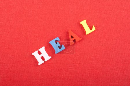 Photo for HEAL word on red background composed from colorful abc alphabet block wooden letters, copy space for ad text. Learning english concept - Royalty Free Image