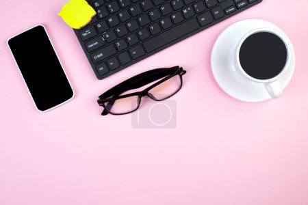 Foto de Mesa de oficina rosa con computadora, bolígrafo y una taza de café, muchas cosas. Vista superior con espacio de copia - Imagen libre de derechos