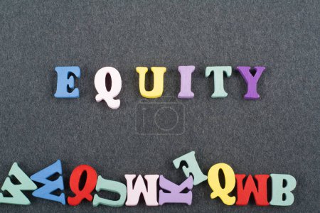 EGUITY word on black board background composed from colorful abc alphabet block wooden letters, copy space for ad text. Learning english concept