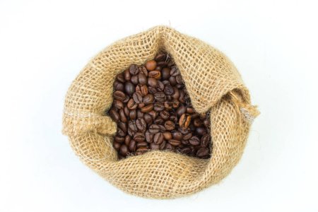 Foto de Bolsas abiertas de arpillera esparcidas con granos de café enteros sobre un fondo blanco - Imagen libre de derechos