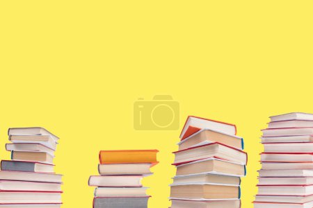 Photo for Composition with hardback books on wooden deck table and yellow background. Books stacking. Back to school. Copy Space. Education background - Royalty Free Image