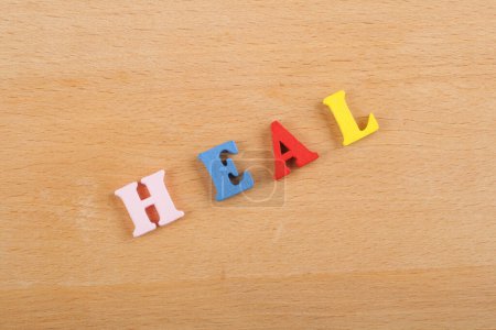 Photo for HEAL word on wooden background composed from colorful abc alphabet block wooden letters, copy space for ad text. Learning english concept - Royalty Free Image