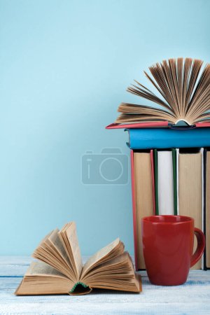 Téléchargez les photos : Livre ouvert, livres à dos dur sur table en bois et fond bleu. Je retourne à l'école. Espace de copie pour le texte - en image libre de droit