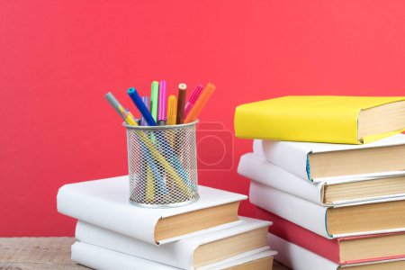 Foto de Libros apilados. Libros sobre mesa de madera y fondo rojo. De vuelta a la escuela. Copiar espacio para texto del anuncio - Imagen libre de derechos